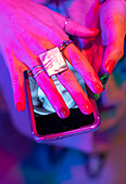 Woman with manicure and rings covering smart phone screen