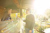 Food truck owner and customer talking in sunny autumn park