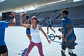 Happy young athletes high fiving on sunny blue sports track