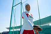 Confident track and field athlete in hijab with discus