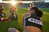 Female athletes stretching before competition