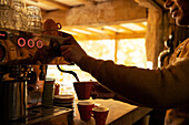 Barista preparing cappuccino at espresso machine in cafe