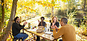 Happy business people clapping and meeting in autumn park