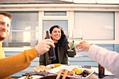 Happy friends toasting wine and beer over seafood lunch