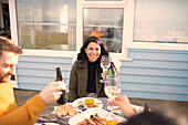 Happy woman enjoying wine and seafood with friends