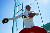 Determined athlete in hijab throwing discus