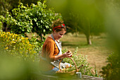 Woman looking at fresh harvested vegetables in garden