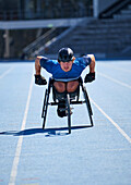 Focused wheelchair athlete training on sports track