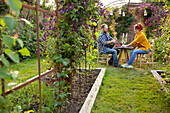 Couple enjoying champagne and red currants in garden