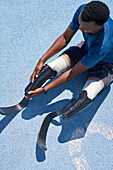 Young athlete with running blade prosthetics on sports track