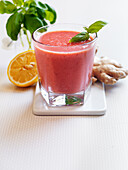 Orange smoothie with strawberries, basil and ginger