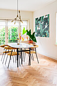 Upholstered chairs around oval table in simple dining room