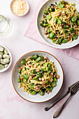 Spaghetti carbonara with broad beans and bacon, grated parmesan