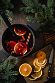 Mulled wine with orange slices and spices in a pot