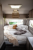 Doppelbett mit Kissen und Tierfell im Wohnwagen