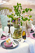 Festively set table with bouquet of wild flowers by the lake
