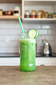 Green smoothie in a screw top glass with a straw