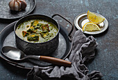 Traditional vegetarian Indian Punjabi food Palak Paneer with spinach and cheese in vintage metal bowl