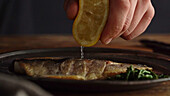 Gebratenen Fisch mit Zitronensaft beträufeln