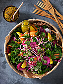 Colorful salad wuth kale, carrots, sesamy seeds, red cabbage, spinache, black radish, coriander and dressing