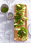 Head lettuce leafs filled with green peas, chicken and avocado