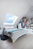 Doppelbett und Garderobenschrank im Schlafzimmer mit Dachschräge