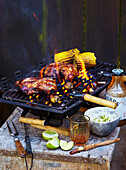 Grilled chicken with sweet Asian marinade and corn on the cob on the grill