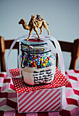 DIY jar with colorful beads and camel figure on dotted base