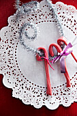 Candy canes with silver decoration on a paper doily
