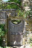 Old garden gate in stone wall