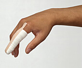 Bandaged finger held in the air