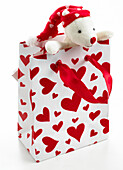 Teddy bear in bag with hearts on