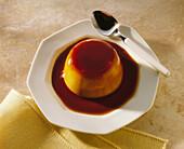 Creme caramel on plate with spoon