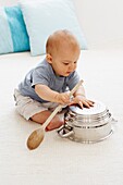 Baby boy playing with colander and spoon