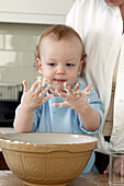 Baby boy with dough-covered hands
