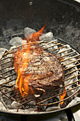Peppered ribeye steak on barbecue grill