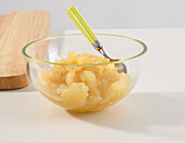 Bowl of apple puree with spoon