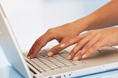 Hands using keyboard of laptop computer