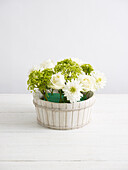 Creating flower arrangement in wooden basket