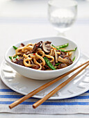 Bowl of ginger beef noodles on plate