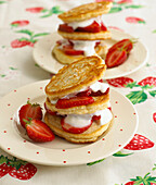 Stack of thick pancakes with strawberries and cream