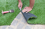 Trimming artificial turf to size using a stanley knife