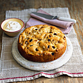 Apple tourte with nuts and raisins, and a bowl of cream