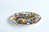 Boiled sweets and chocolate chunks on colourful paper plate