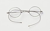 Pair of round metal-rimmed eyeglasses with thin metal bows