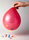 Hand holding red balloon with stickmen cut-outs attached