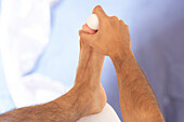 Man massaging foot with golf ball