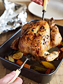 Removing cooked roast chicken from roasting pan