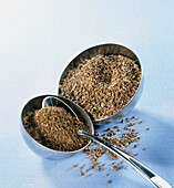 Pimpinella anisum whole and ground seeds in metal bowls