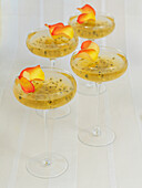 Four glasses of sparkling wine jellies with passion-fruit